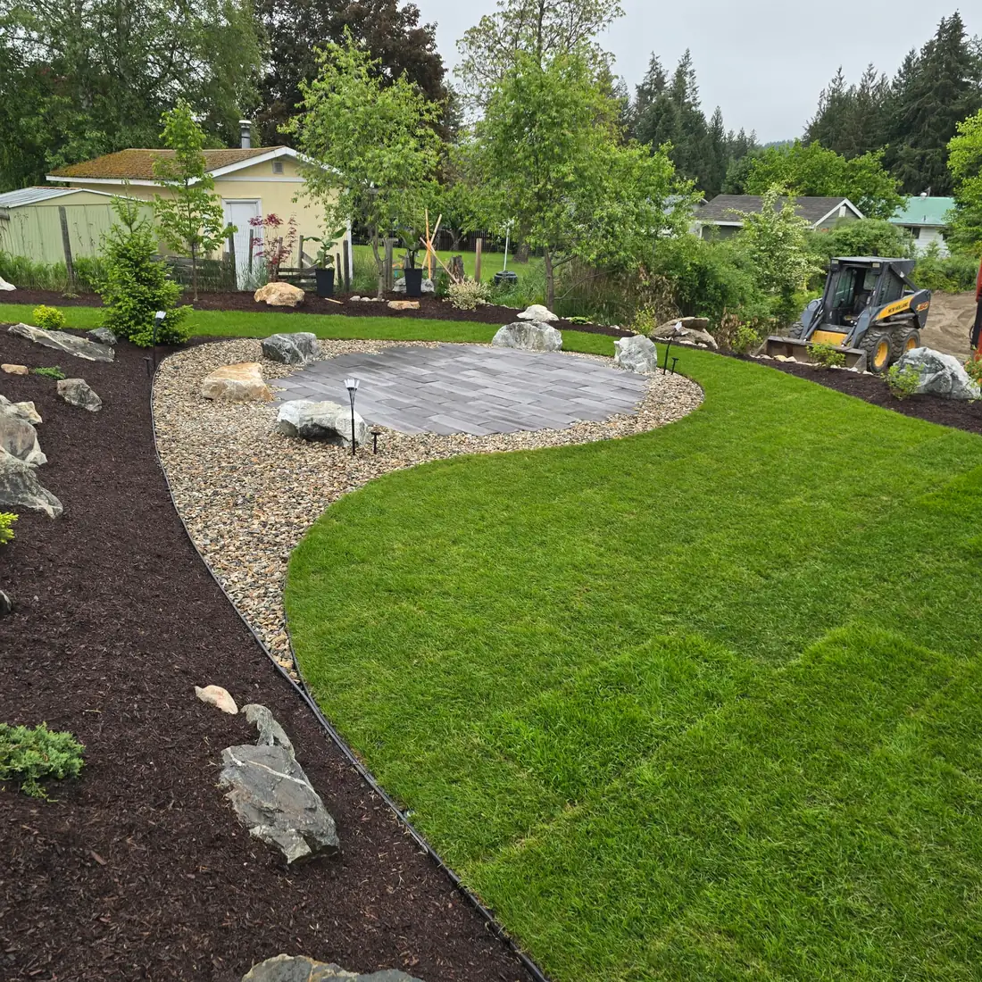 Completed full-yard landscape build with lawn, beds and paver patio, Salmon Arm BC