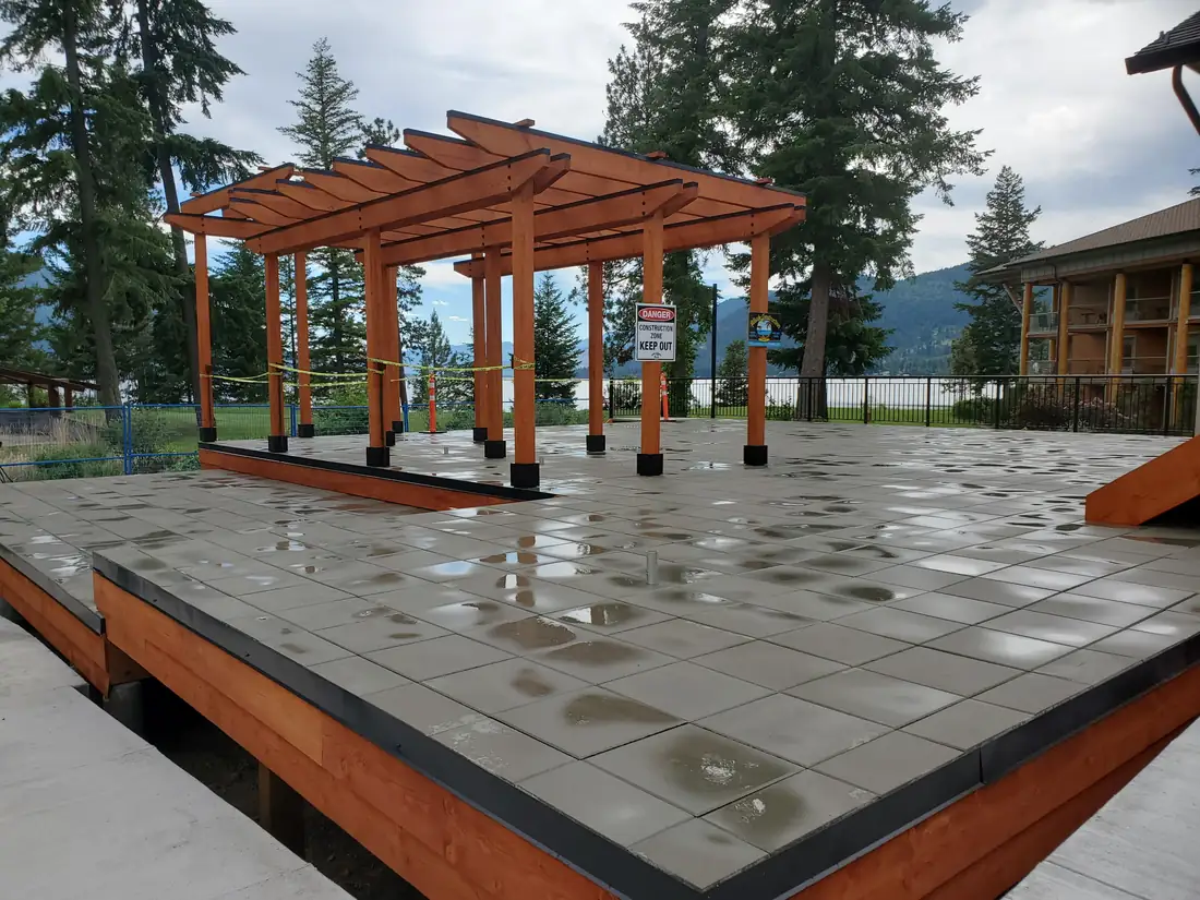 Commercial pedestal-set floating patio slabs under cedar pergolas