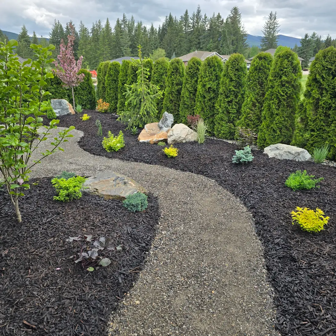 Finished garden beds with feature boulders and gravel path by Everything Earth