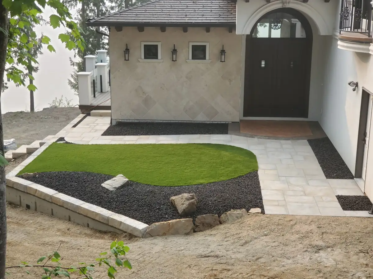 Full hardscape package — stone paver patio, artificial turf, stone curb wall and landscape lighting, Eagle Bay BC