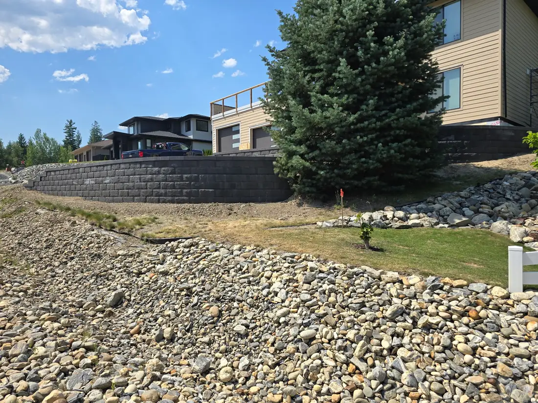 Curved block retaining wall with river rock swale, Salmon Arm BC